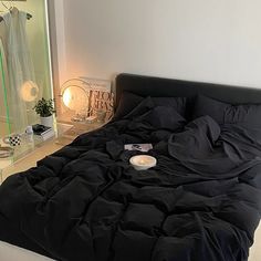 a bed with black sheets and pillows in a room