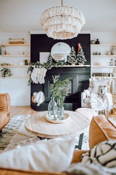 a living room filled with furniture and a fire place under a chandelier over a fireplace