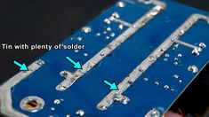 the inside of an electronic board with two screws and some water droplets on it