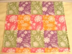 a quilted square with flowers and leaves on it