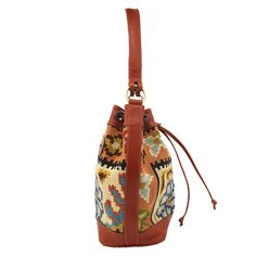 Our Bucket Bag is the perfect addition to any closet for the on-the-go trendsetter. This vintage Kilim bag can fit your everyday essentials whether you are running errands, on a date night, or even while traveling.The drawstring closure creates a unique silhouette while still protecting all of your belongings from falling out. You can utilize the interior open pocket and zipper pocket for loose change, sunglasses, or a small makeup bag. The structured brown genuine leather base with brass feet h Kilim Bag, Small Makeup Bag, Loose Change, Small Makeup, Leather Bucket Bag, Leather Bucket, Everyday Essentials, Leather Top, Vintage Kilim