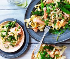 two plates of pasta with salmon, asparagus and spinach garnish