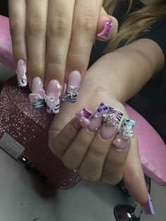 a woman with pink and white nail polish on her nails holding onto a pink object