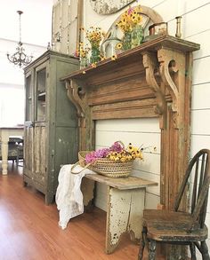 an old fireplace with flowers on top and a basket full of daisies sitting next to it