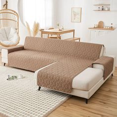 a living room with a couch, chair and rug on the wooden floor in front of a window