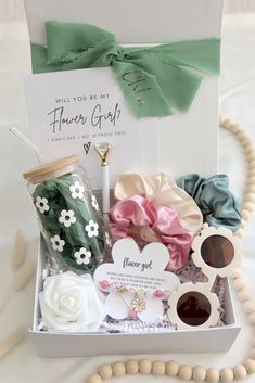 the flower girl gift box is filled with flowers and accessories