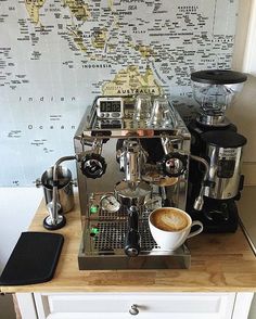 a coffee machine sitting on top of a wooden counter next to a wall with a map