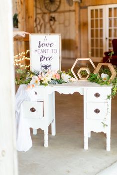 a white desk with flowers on it and a sign that says save meant to be