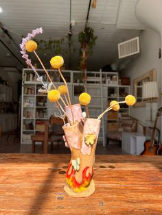 a vase filled with yellow flowers on top of a wooden table