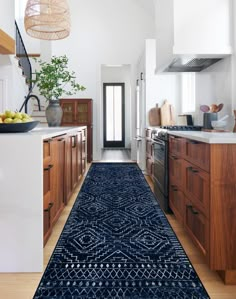 a kitchen with wooden cabinets and an area rug