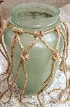 a green vase with rope wrapped around it