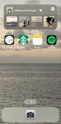 an iphone screen with various icons on it and the ocean in the backgroud