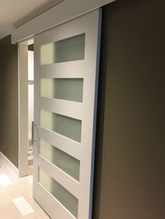 a white door with frosted glass on the front and side panels in an empty room