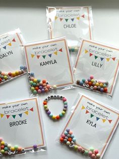 four bags of personalized bracelets with name tags on them and some beads in the middle