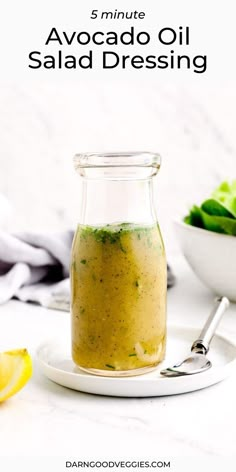 a glass jar filled with salad dressing on top of a white plate