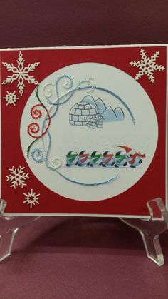 a red and white christmas card with snowflakes on the bottom, an igloose in the middle