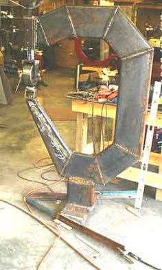 a large metal object sitting on top of a wooden table in a room filled with tools