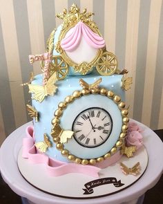 a blue cake with gold decorations and a clock on top