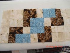 a piece of cloth that has been made into a quilt with blue and brown squares on it