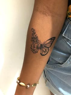 a woman's arm with a butterfly tattoo on the left side of her arm