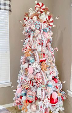 a white christmas tree decorated with lollipops, candy and other candies