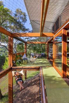 a woman is sitting on a hammock in the yard