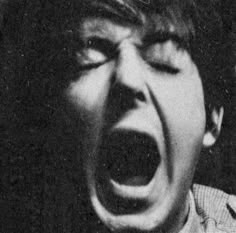 an old black and white photo of a young man screaming