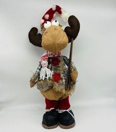 a stuffed moose with a hat and scarf holding a stick