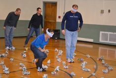 a group of people standing on top of a basketball court covered in paper machs