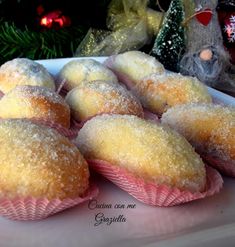 a bunch of muffins sitting on top of a table next to a christmas tree