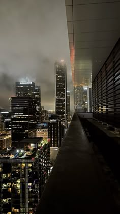 the city skyline is lit up at night, with skyscrapers in the foreground