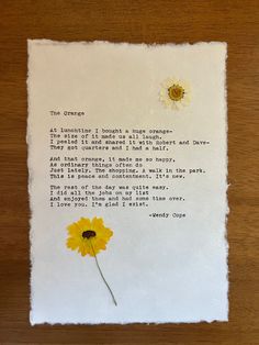 a piece of paper with a poem written on it and two yellow flowers in the middle