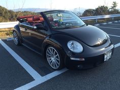 a black convertible car parked in a parking lot