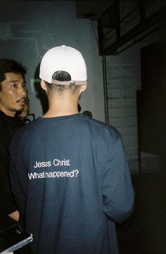 two men standing next to each other in front of a white wall with the words jesus christ what happened? on it