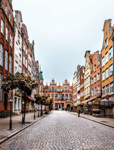 a cobblestone street in an old european city with tall buildings on either side