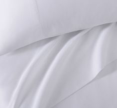 the white sheets and pillow cases are neatly made