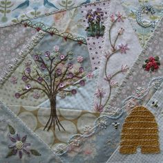 a patchwork quilt with an elephant and tree on it's side, surrounded by flowers