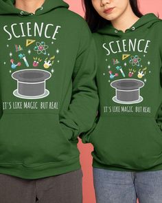 two people wearing green hooded sweatshirts with science on the front and one has a top hat