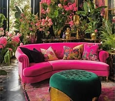 a living room filled with lots of pink furniture and flowers on the wall behind it