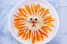 an animal made out of carrots on a white plate with red border around it