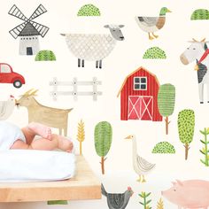 a baby is laying on a bed in front of farm animals and barnyards