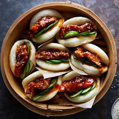 a wooden bowl filled with dumplings covered in sauce