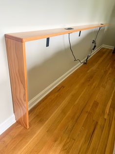 a wooden table sitting on top of a hard wood floor next to a white wall