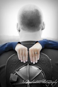 a man with his hands on the back of an iron wheel and wearing a ring