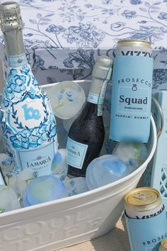 an ice bucket filled with bottles of alcohol and other items next to a table cloth