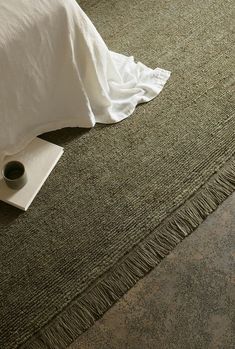 a close up of a bed with a pillow and blanket on the floor next to it