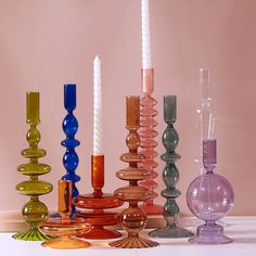 there are many different colored candles on the table