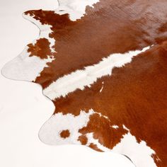 a brown and white cowhide rug on the floor