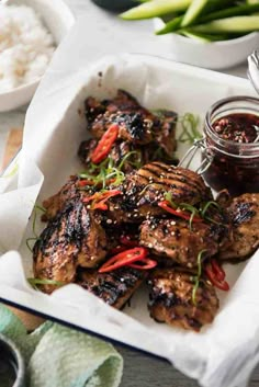 grilled chicken wings with sauce in a red frame on a white plate and green onions