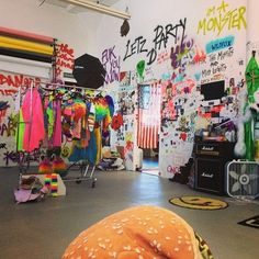 a large hamburger sitting on top of a floor next to a wall covered in graffiti